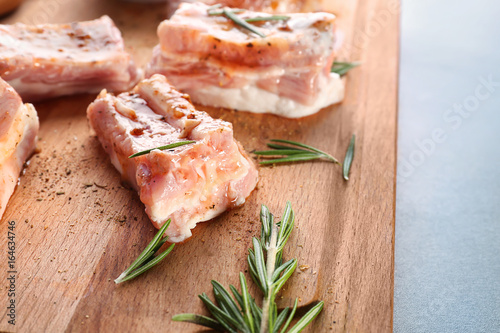 Pork ribs and rosemary on wooden board, closeup