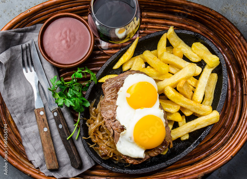 Peruvian Latin American food. Lomo a lo pobre. Beef tenderloin whit fried potatoes french fries and eggs photo