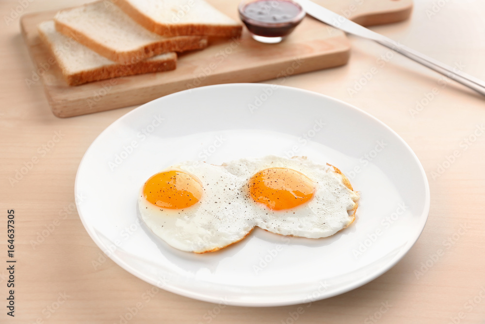 Composition with sunny side up fried eggs, bread and jam on wooden table Composition with sunny side up fried eggs, bread and jam on wooden table