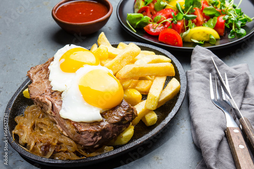 Peruvian Latin American food. Lomo a lo pobre. Beef tenderloin whit fried potatoes french fries and eggs photo