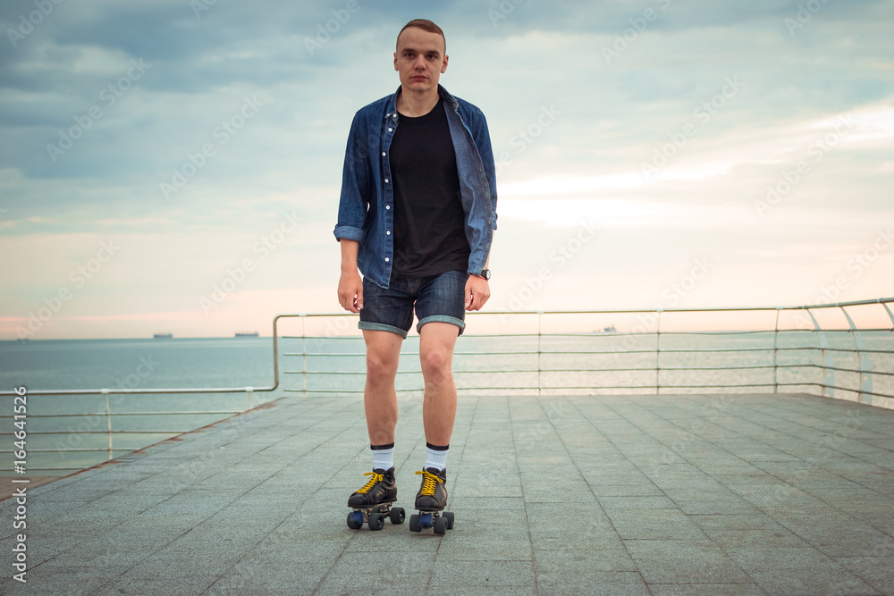 Young caucasian man roller skating with quad skates near the sea Stock  Photo | Adobe Stock