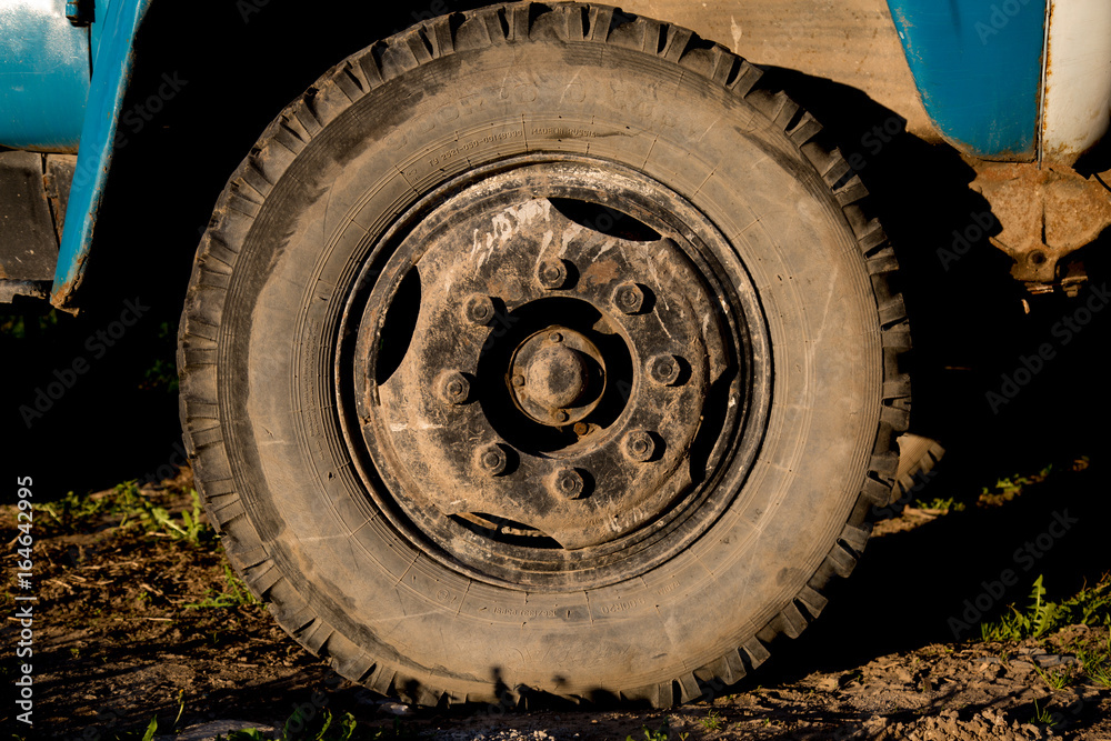 Dirty truck's wheel background soil sunshine day 