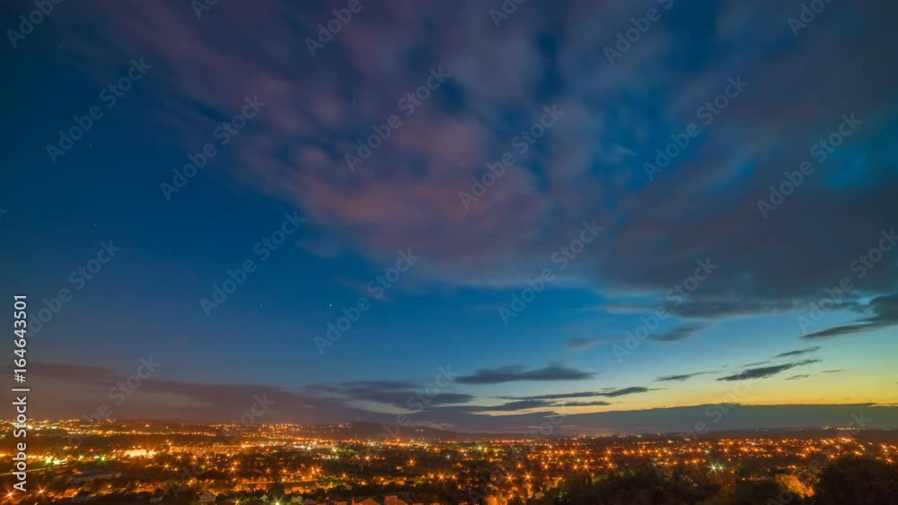 The clouds stream over the city. day to night transition. time lapse