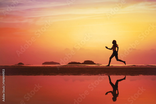 sport background  silhouette of woman running on the beach