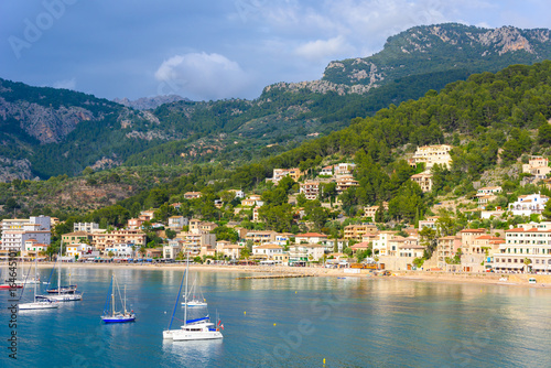 Puerto de Soller, Port of Mallorca island in balearic islands, Spain. Beautiful  beach and bay with boats in clear blue water of summer day. © Simon Dannhauer