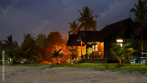 Illuminated tropical beach house at night