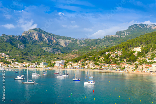 Puerto de Soller, Port of Mallorca island in balearic islands, Spain. Beautiful  beach and bay with boats in clear blue water of summer day. photo