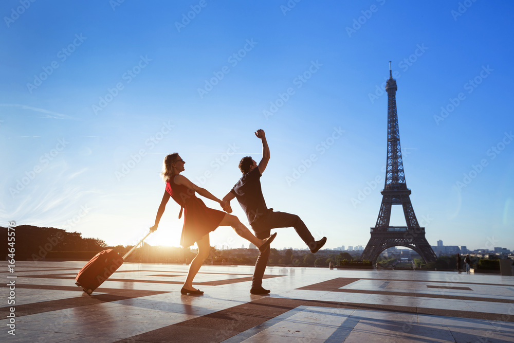 Fototapeta premium para szalonych turystów na wakacjach w Paryżu, mężczyzna i kobieta bawią się blisko Wieży Eiffla, podróżują z bagażem, turystyka
