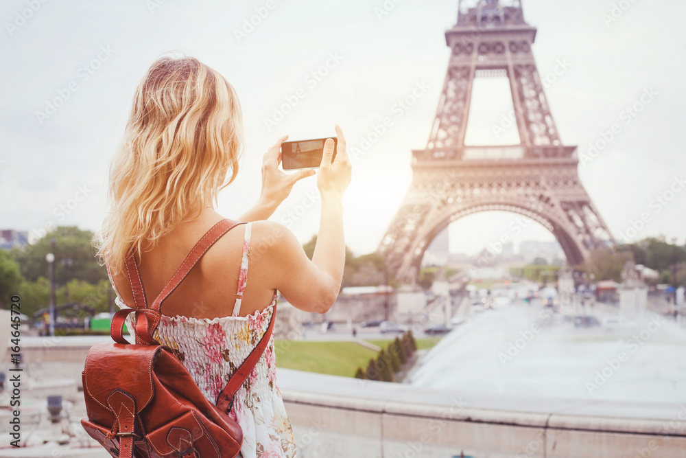 Naklejka premium turysta w Paryżu odwiedzając punkt orientacyjny Wieża Eiffla, zwiedzanie we Francji, kobieta biorąc zdjęcie na telefon komórkowy