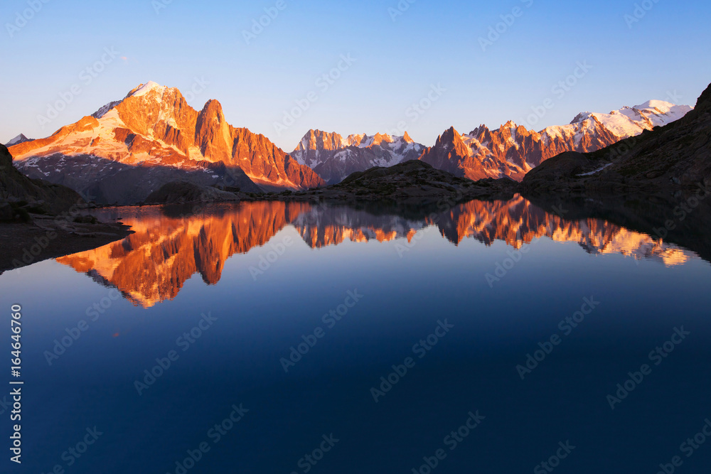 beautiful mountains skyline landscape at sunset, panoramic view of Alps with reflection in lake, nature background with copyspace