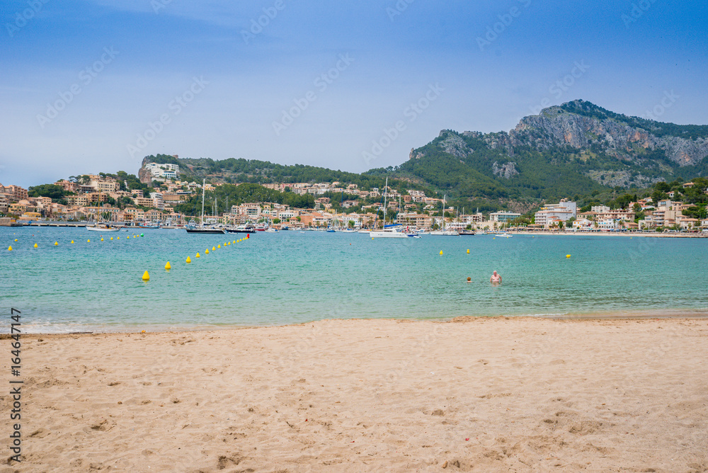 Puerto de Soller, Port of Mallorca island in balearic islands, Spain. Beautiful beach and bay with boats in clear blue water of summer day. Puerto de Soller, Port of Mallorca island in balearic islands, Spain. Beautiful beach and bay with boats in clear blue water of summer day.