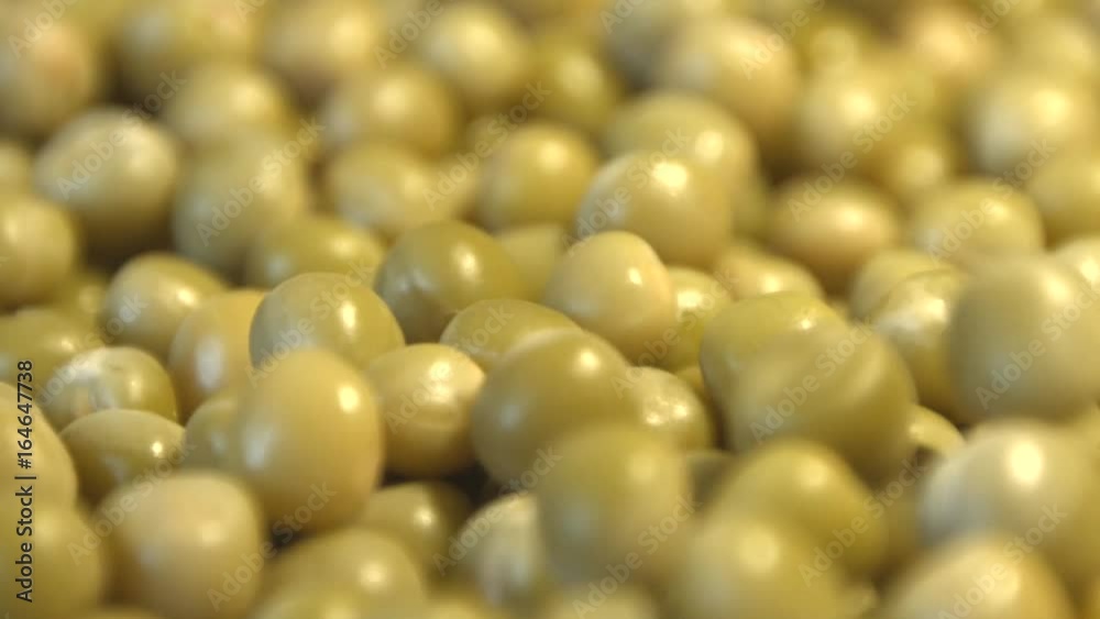 Canned green peas. 2 Shots. Slow motion. Vertical and horizontal pan. Close-up.