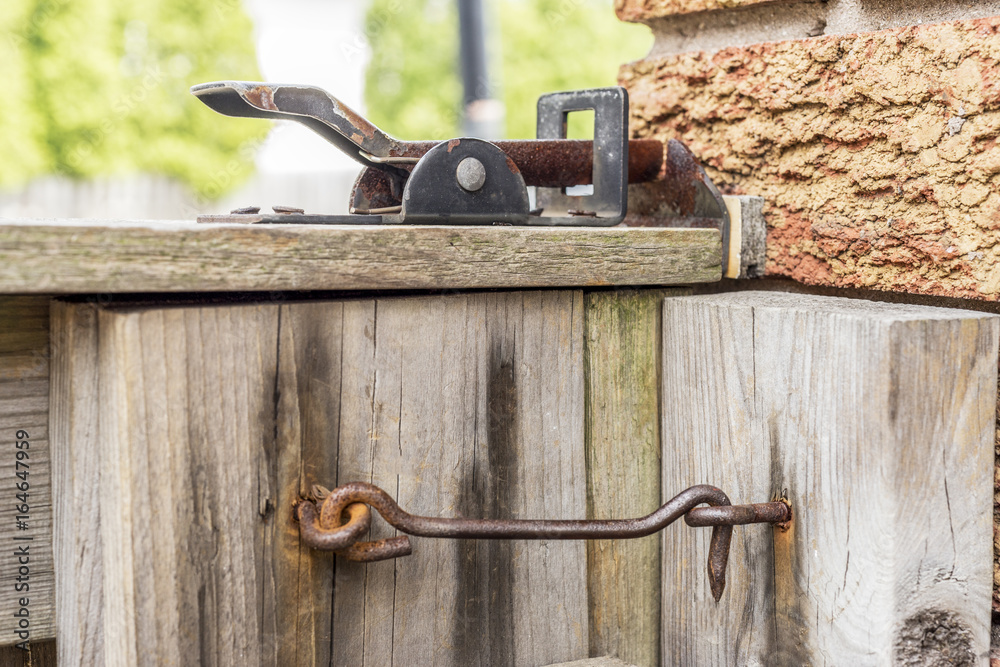 Old ineffective rusty latches on wooden gate to backyard Old ineffective rusty latches on wooden gate to backyard