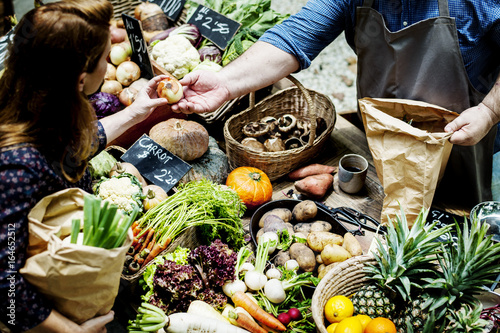Fotografering People buying fresh organic vegetable at market