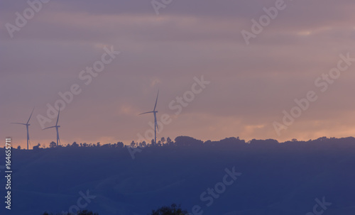 Wind turbines for electricity on a mountain at sunset. © thanavut