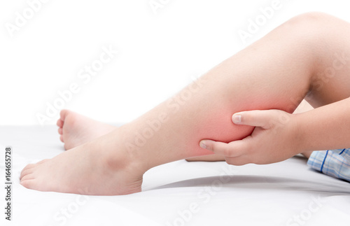 Leg pain or calf muscle in a boy on bed isolated
