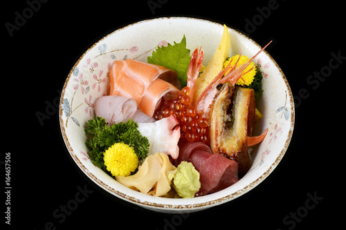 Chirashi sashimi don or mixed fresh sea food on rice in ceramic of Japanese tradition cuisine food with black isolated background