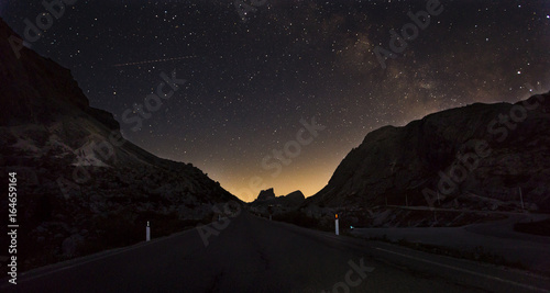 Canvas Print Starry night sky with the Milky Way over a mountain road