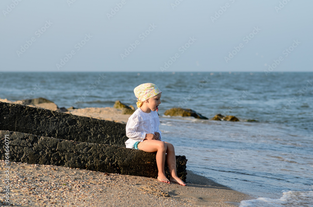 Girl playing on the beach with shells.