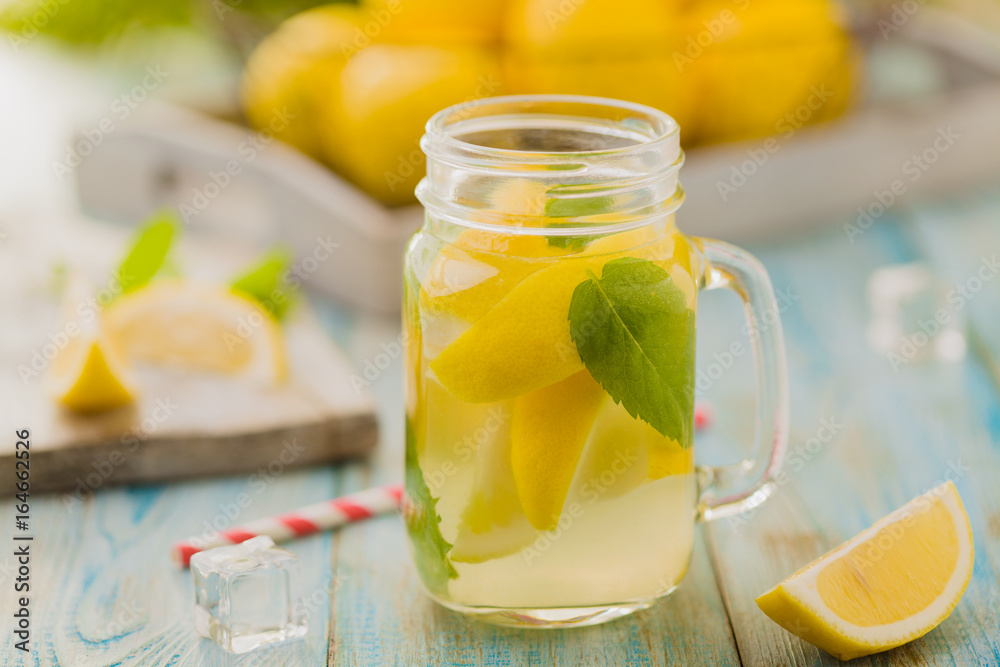 lemonade with mint on rocks served in jar with a straw