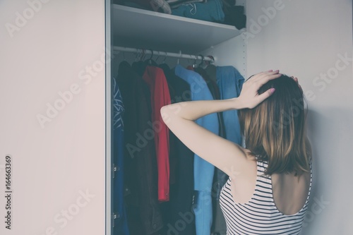 Young rednead girl choosing a clothes