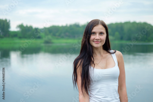 Portrait of a beautiful girl in the background of a lake