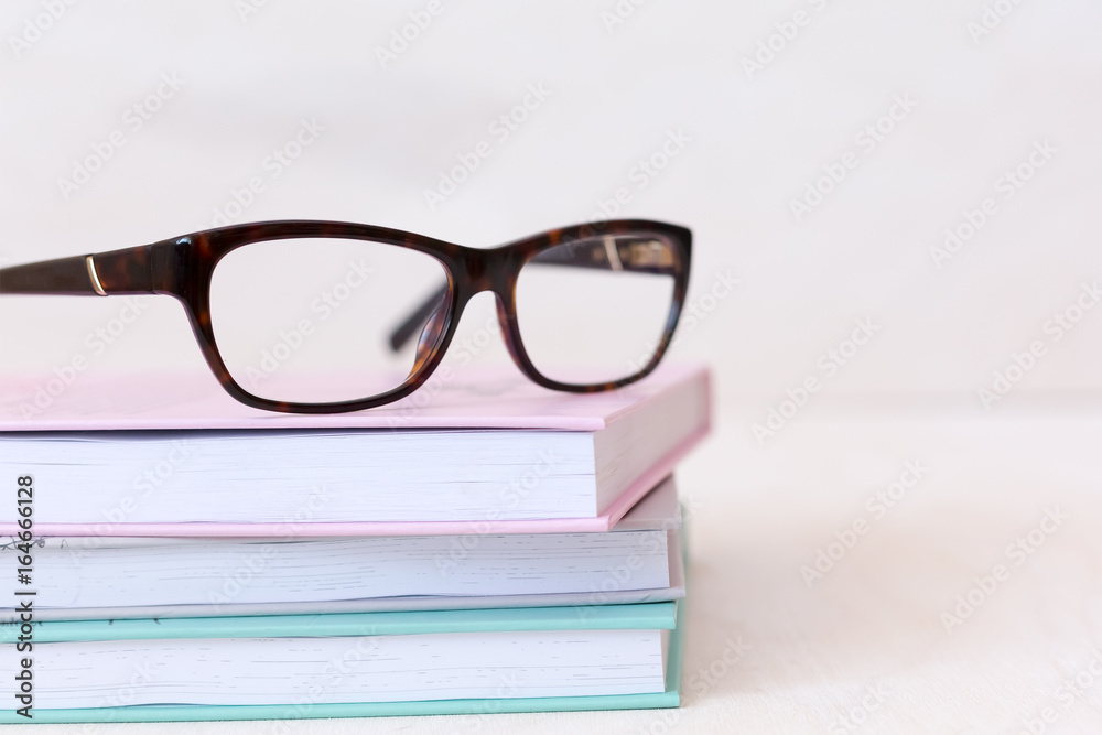 Modern book and eye glasses for read and write, education, eye health concept - selective focus close up Modern book and eye glasses for read and write, education, eye health concept - selective focus close up