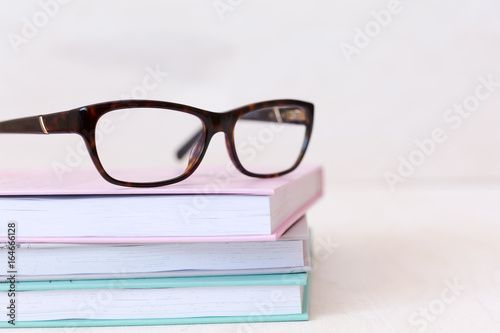 Modern book and eye glasses for read and write, education, eye health concept - selective focus close up