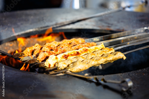 Eastern dish of meat kebab cooked on the skewer over the fire in the street