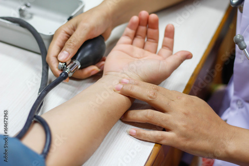 Doctor tests blood pressure of patients.