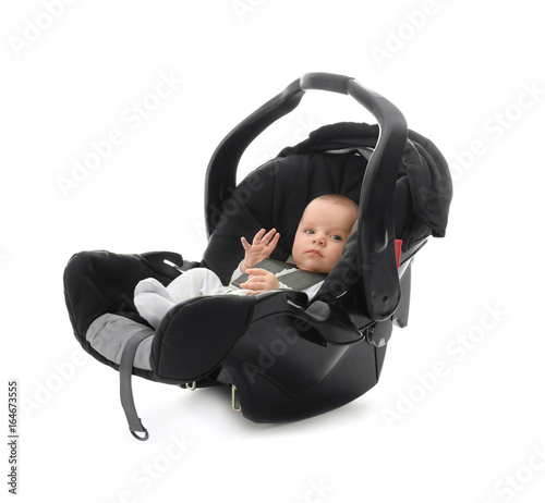 Foto Adorable baby boy sitting in car seat with safety belt on white background