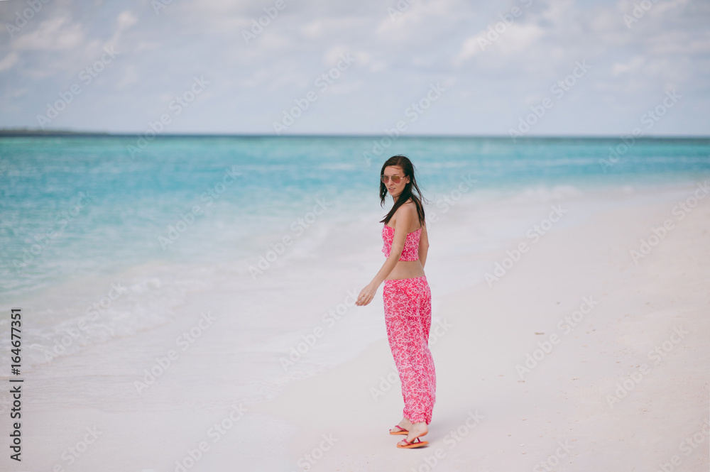 Girl in pink clothes on the beach of the island Girl in pink clothes on the beach of the island
