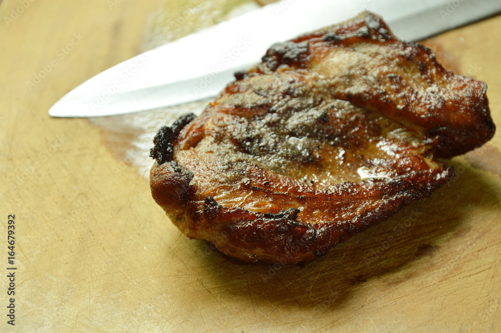 pepper pork steak and knife blade on wooden chop block pepper pork steak and knife blade on wooden chop block