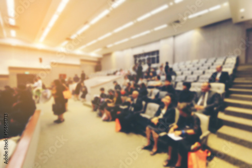 Blurred image of business Conference and Presentation with public presentations. Audience at the conference hall. Entrepreneurship club. Background blur. vintage tone with orange light effect.