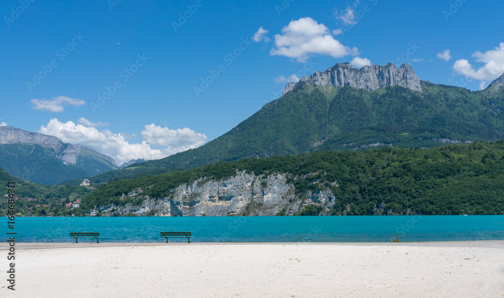 Benches on the sand in front of Lac d'Annecy, France.