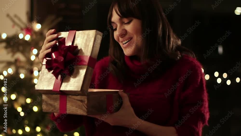 Amazed young woman looking at magical christmas gift in the box Amazed young woman looking at magical christmas gift in the box