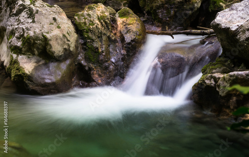 Cascade falls over mossy rocks © rosewind