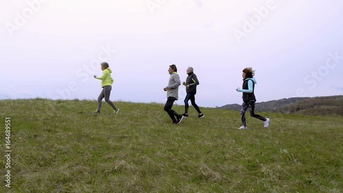 Wallpaper Mural Group of seniors running outside on the green hills. Torontodigital.ca