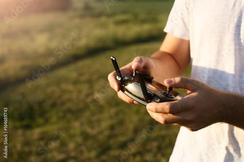 Man holds a drone remote controller in his hands. Close-up of quadrocopter RC during flight. Pilot takes aerial photos and videos with quad photo