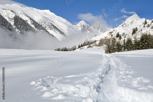 piste dans la neige traversant la montagne © coco
