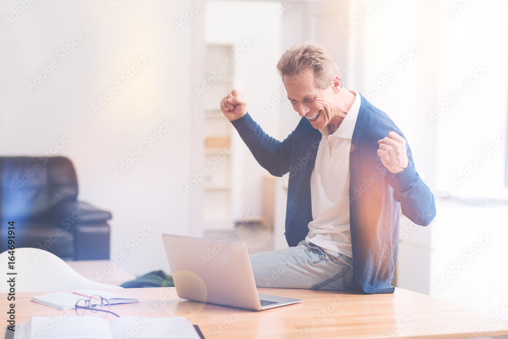 Joyful freelance worker sitting on the table Joyful freelance worker sitting on the table
