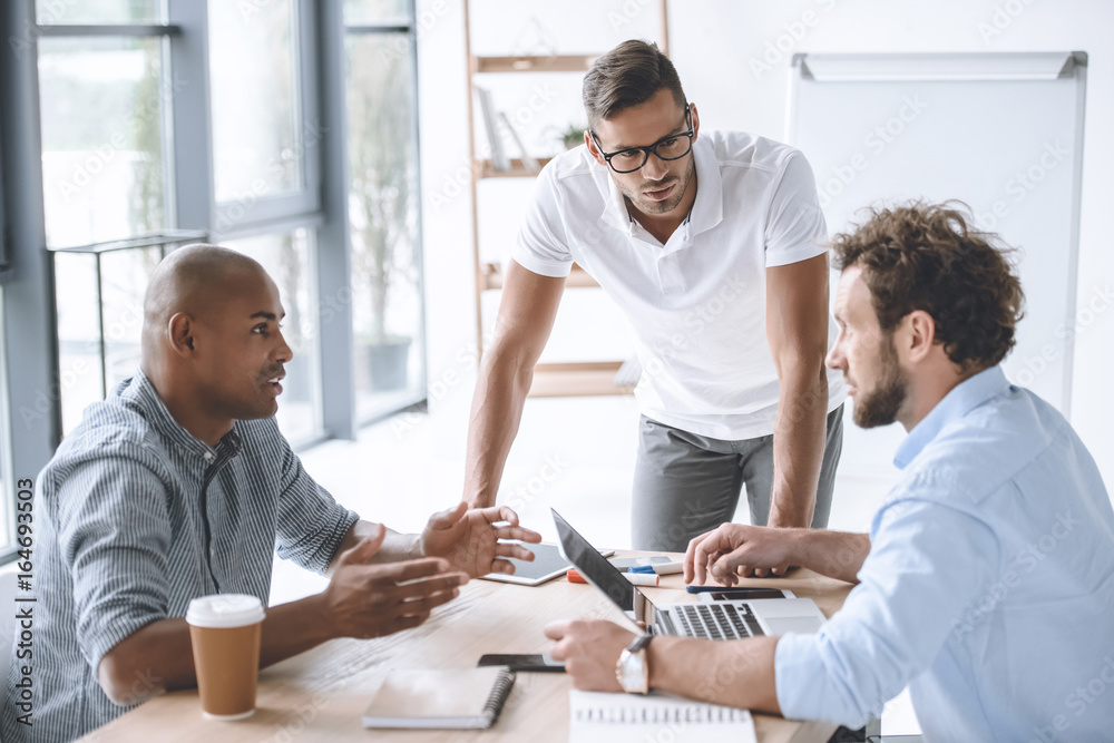 multiethnic group of businessmen having discussion at meeting in office multiethnic group of businessmen having discussion at meeting in office