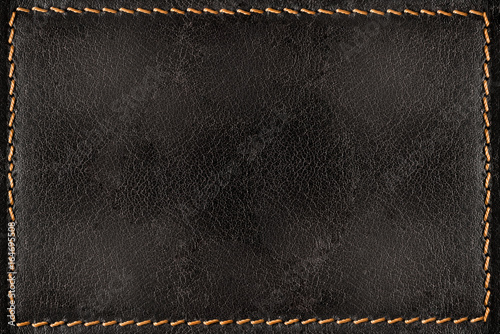 Black leather texture background with orange seams