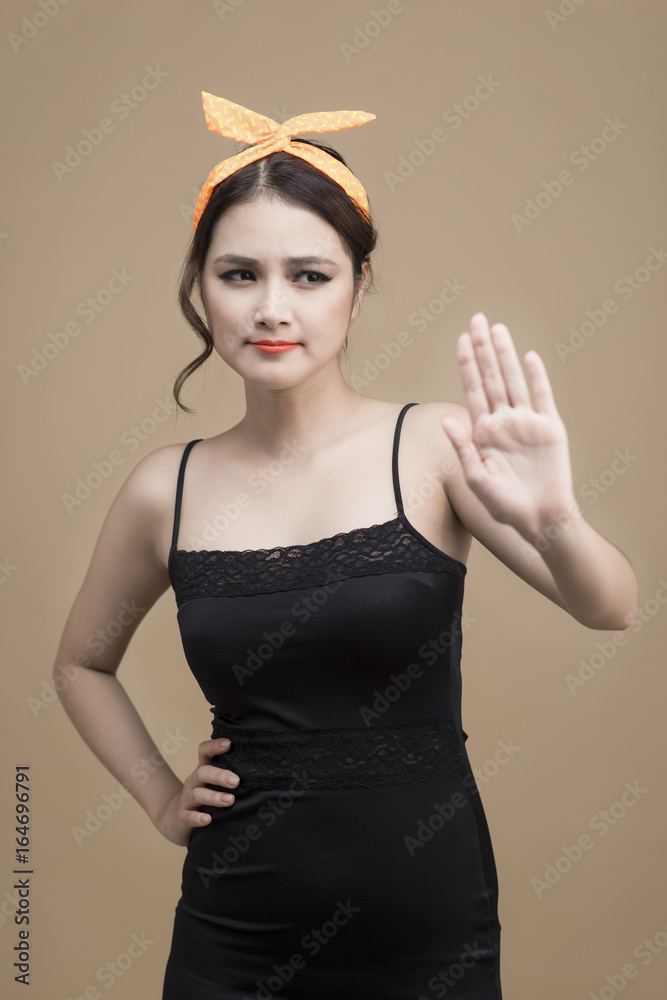 Portrait of asian girl with pretty smile in pinup style with hands gesture on yellow background Portrait of asian girl with pretty smile in pinup style with hands gesture on yellow background