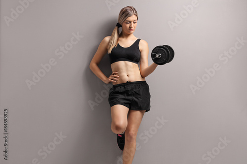 Attractive young woman with a dumbbell