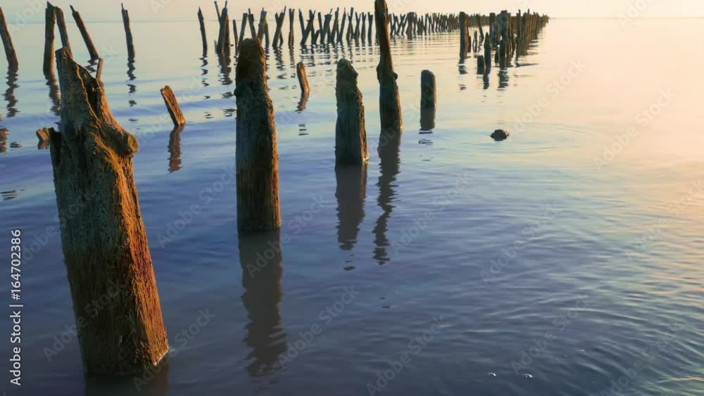 Lake early in morning / Ruined wooden pier on blue lake Lake early in morning / Ruined wooden pier on blue lake