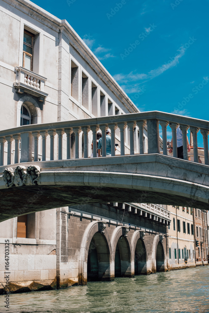 View on a venetian canal with ancient buildings and bridge in Venice View on a venetian canal with ancient buildings and bridge in Venice