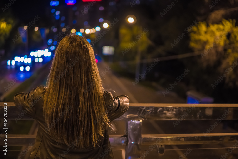 Young woman watching the view night city road from bridge Young woman watching the view night city road from bridge
