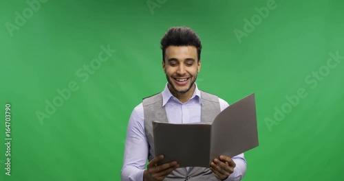Happy Smiling Businessman Read Documents Over Chroma Key Green Screen Hold Reports Cheerful Portrait of Young Latin Business Man