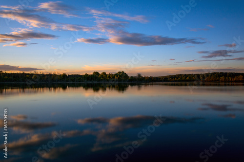 Smooth surface of lake at sunset